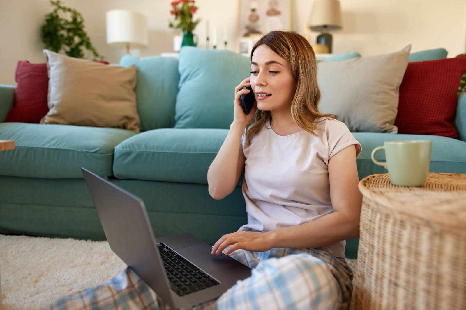 Woman on her laptop talking on the phone.